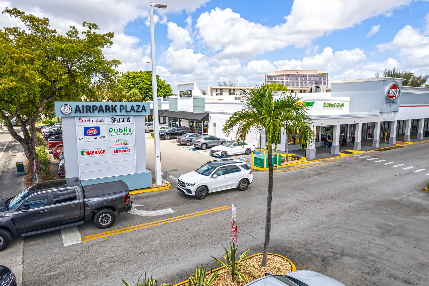 Airpark Plaza monument sign and storefronts along NW 7th Street