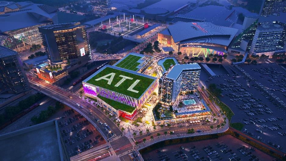 Aerial rendering of Centennial Yards at night, with State Farm Arena and the downtown Atlanta skyline beyond