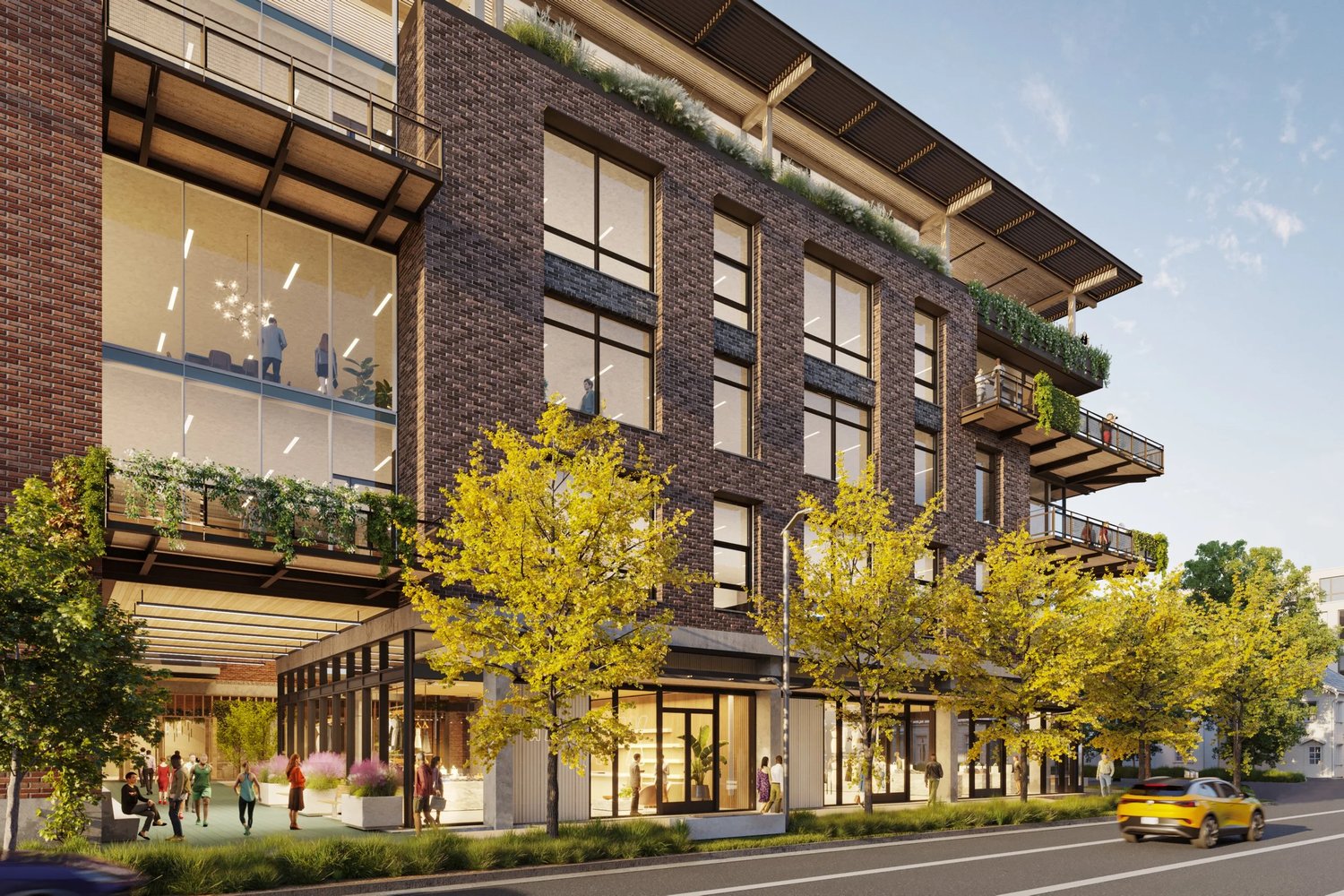 Street-level rendering of the 5th & Walsh office building showing its brick facade and landscaped terraces