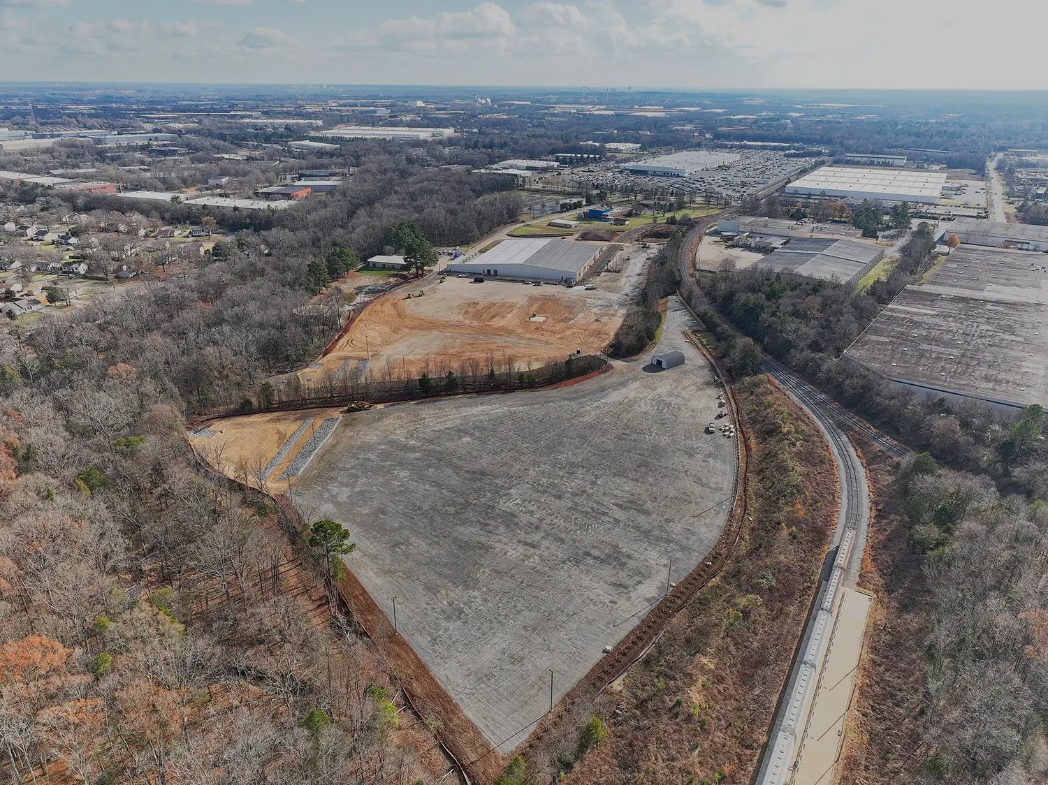 Aerial view of the cleared and graded redevelopment site at 8309 Wilkinson Blvd