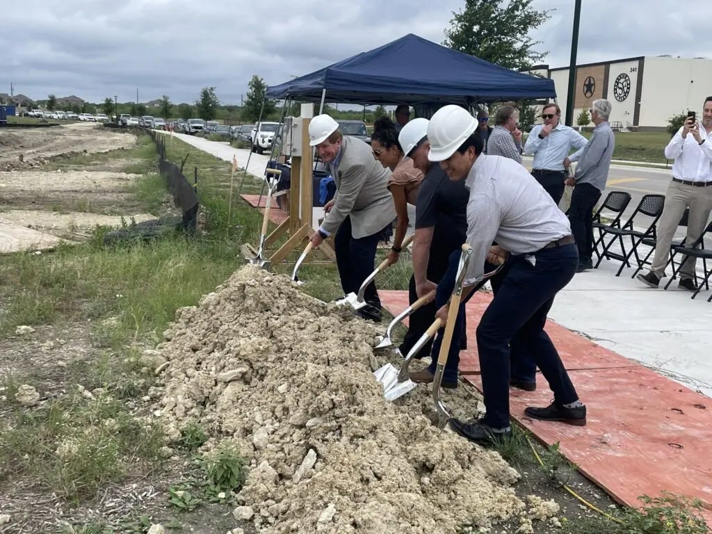 Attendees turn the first dirt at the Kyle Technology Park site