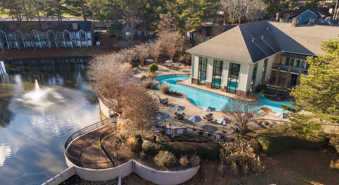 Aerial view of the clubhouse, pool, and lake at East Ponce Village in Stone Mountain