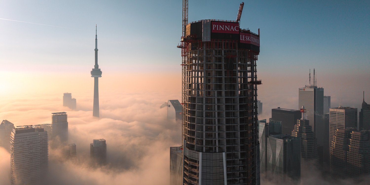 SkyTower under construction above the Toronto skyline, with Pinnacle branding on the crane enclosure