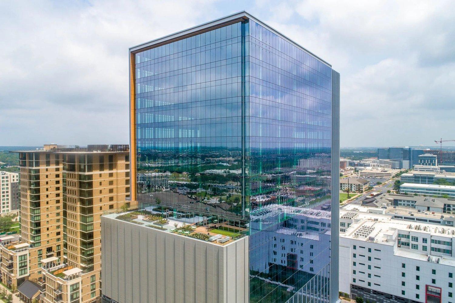 Close-up aerial of Domain Tower 2's glass curtain wall and terrace level